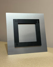 Load image into Gallery viewer, Back view of a 12 x 12 metal print with mount on a beige surface with a neutral background
